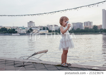 Littel girl drinking a glass of water Littel girl drinking a glass of water 21323674
