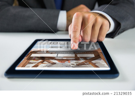 Composite image of businessman using digital tablet 21329035