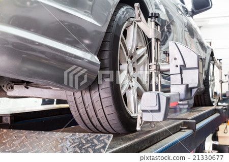 Tire clamped with aligner undergoing wheel align 21330677