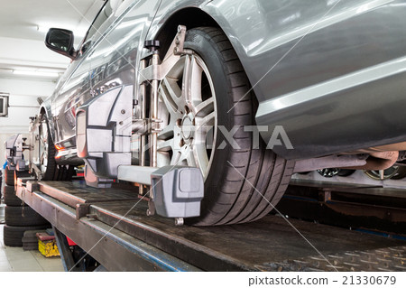 Tire clamped with aligner undergoing wheel align Tire clamped with aligner undergoing wheel align 21330679
