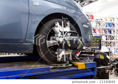 Tire clamped with aligner undergoing wheel align Tire clamped with aligner undergoing wheel align 21330684