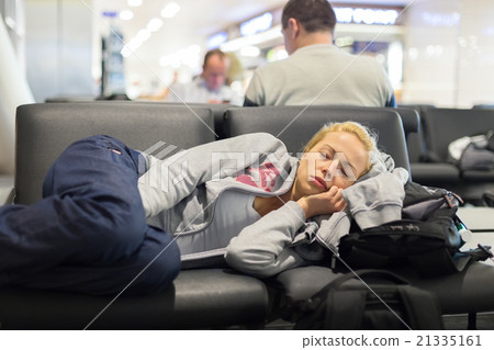 Tired female traveler sleeping on airport. 21335161