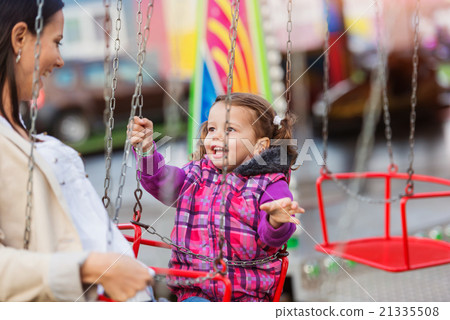 Mother and daughter at fun fair, chain swing ride 21335508