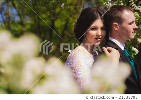 Young bride and groom in a lush garden  21335795