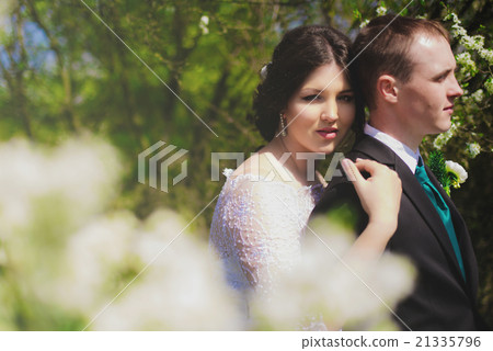 Young bride and groom in a lush garden Young bride and groom in a lush garden 21335796