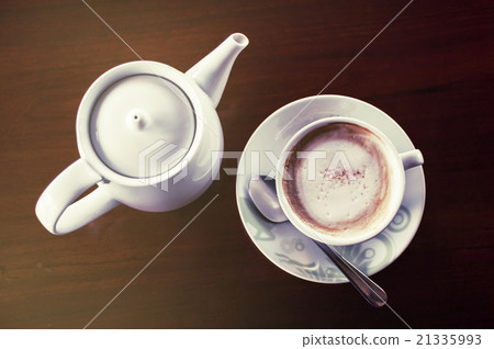 Cup of coffee with hot tea pot on a dark wooden Cup of coffee with hot tea pot on a dark wooden 21335993