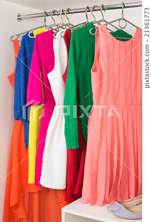 row of bright dress hanging on coat hanger row of bright dress hanging on coat hanger 21361773