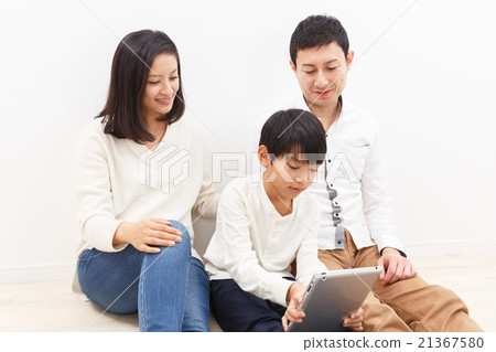Three family members watching tablets 21367580