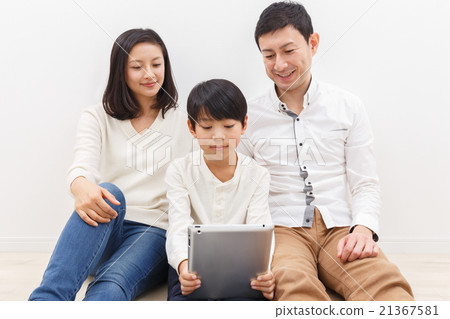 Three family members watching tablets Three family members watching tablets 21367581