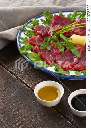 Carpaccio on the white plate on the wooden table Carpaccio on the white plate on the wooden table 21372795