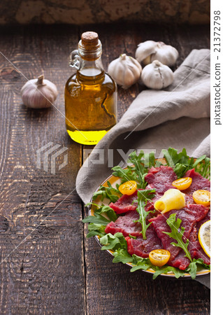 Carpaccio on the white plate on the wooden table Carpaccio on the white plate on the wooden table 21372798
