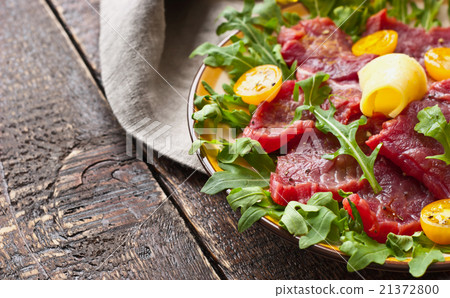 Carpaccio on the white plate on the wooden table Carpaccio on the white plate on the wooden table 21372800