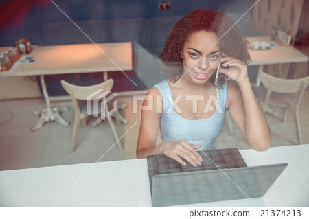 Pleasant girl sitting at the table Pleasant girl sitting at the table 21374213