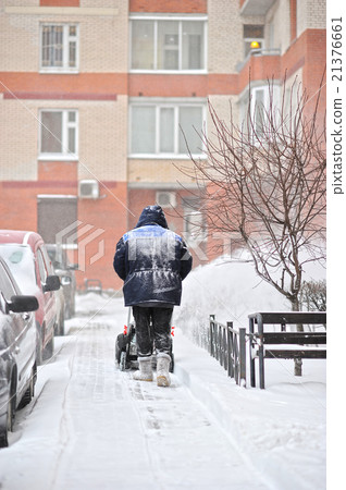 man removes snow in the yard man removes snow in the yard 21376661