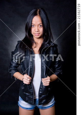 Asian girl in studio on dark background Asian girl in studio on dark background 21382719