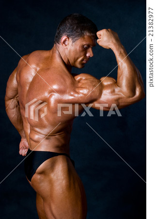 Young athletic man showing his muscles Young athletic man showing his muscles 21382977