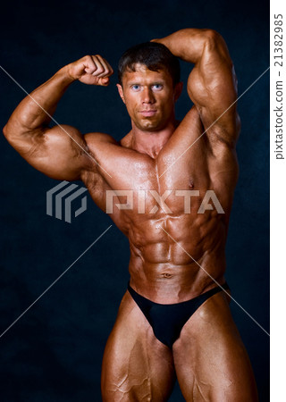 Young athletic man showing his muscles Young athletic man showing his muscles 21382985