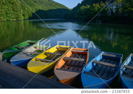 Multicolored boats on lake Multicolored boats on lake 21387855