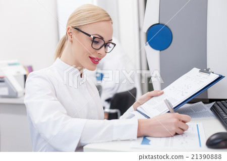 Cute young scientist is noting her findings Cute young scientist is noting her findings 21390888