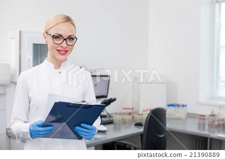 Cheerful young scientist is working in lab Cheerful young scientist is working in lab 21390889