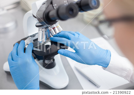 Cheerful young scientist is doing her research Cheerful young scientist is doing her research 21390922