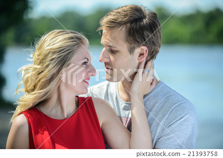 young couple sitting on the sand smiling, hugging young couple sitting on the sand smiling, hugging 21393758