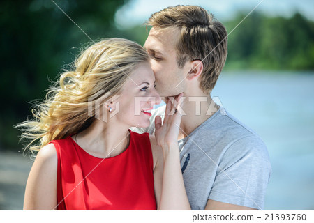 young couple sitting on the sand smiling, hugging young couple sitting on the sand smiling, hugging 21393760