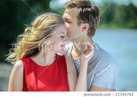 young couple sitting on the sand smiling, hugging young couple sitting on the sand smiling, hugging 21393762