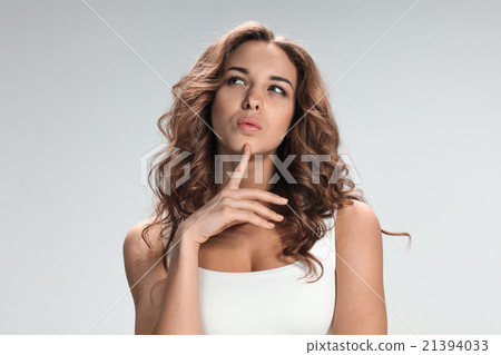 The happy thoughtful woman on gray background The happy thoughtful woman on gray background 21394033
