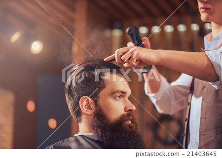 Professional barber styling hair of his client Professional barber styling hair of his client 21403645