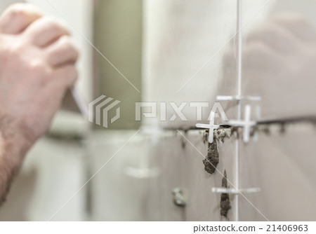 Worker tiler puts ceramic tiles Worker tiler puts ceramic tiles 21406963