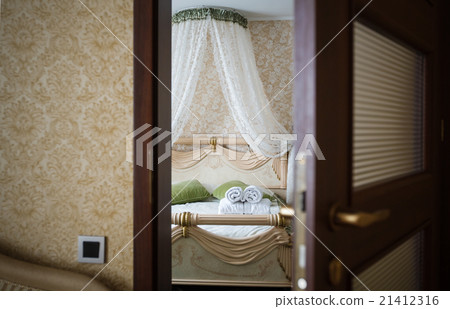 Half open door of a hotel bedroom 21412316