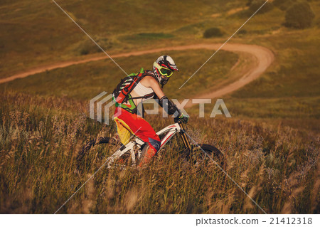 Extreme sports - young woman riding downhill bike 21412318