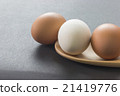 White and brown eggs in wooden ladle 21419776