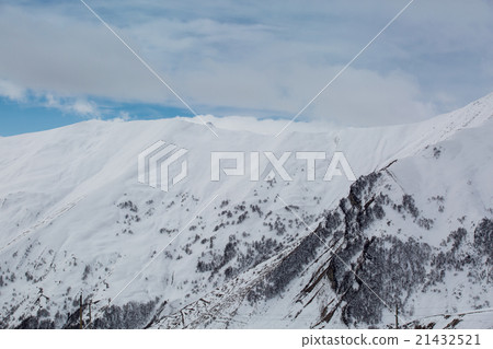 blue skies with clouds over the mountains in snow 21432521