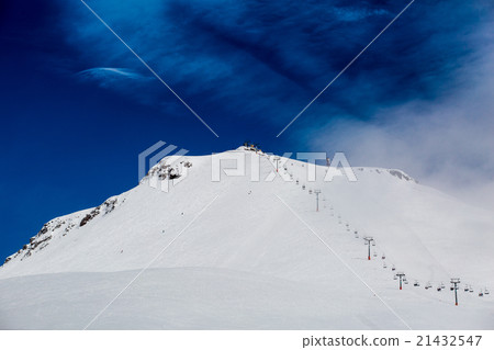 blue skies with clouds over the mountains in snow 21432547