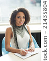 Pleasant girl sitting at the table 21435804
