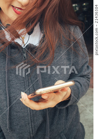 Woman listening to music on earphone Woman listening to music on earphone 21436384