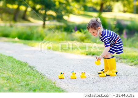 Little girl playing in forest and wearing boots Little girl playing in forest and wearing boots 21440192