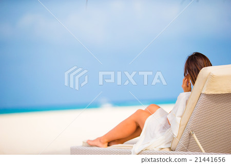 Young woman on lounger with mobile phone at the Young woman on lounger with mobile phone at the 21441656