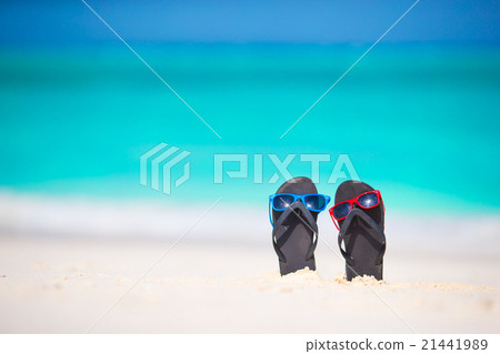 Summer flip flops with sunglasses on white beach 21441989