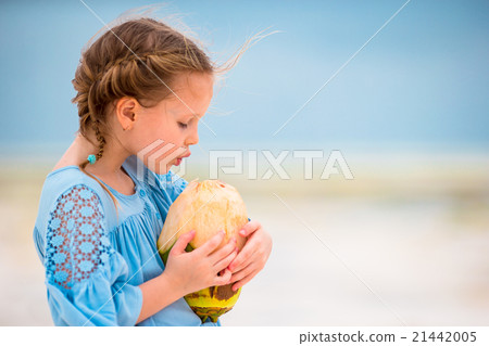 Little adorable girl drinking coconut milk on the 21442005