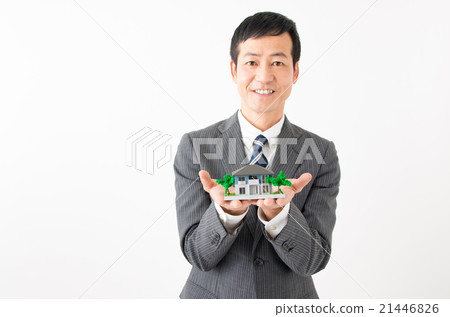 A businessman with a house model in hand 21446826