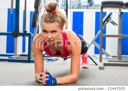 woman doing some push ups in gym. 21447035