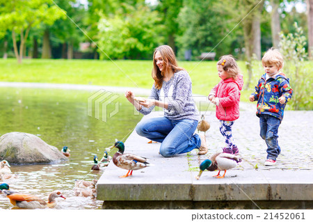 Mother and her children feeding ducks at summer Mother and her children feeding ducks at summer 21452061