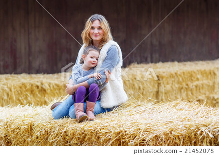 happy girl and mother having fun with hay on a happy girl and mother having fun with hay on a 21452078
