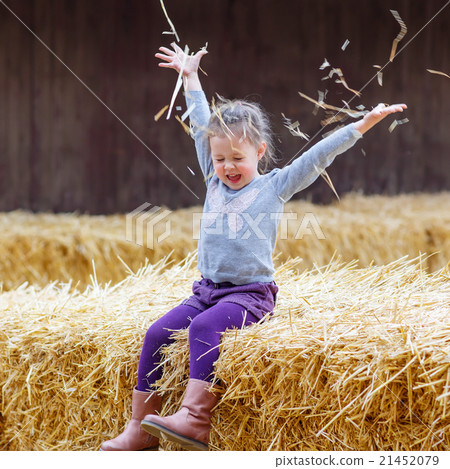 happy girl having fun with hay on a farm happy girl having fun with hay on a farm 21452079