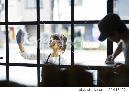 A woman wiping a window A woman wiping a window 21452432
