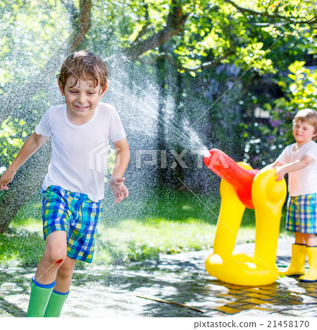 Two little kids playing with garden hose in summer 21458170