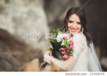 Beautiful bride posing near rocks with beautiful 21458479